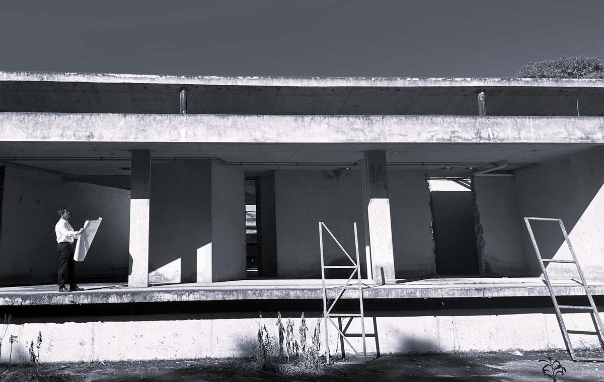 Engenheiro analisando prancha do projeto em estrutura de concreto