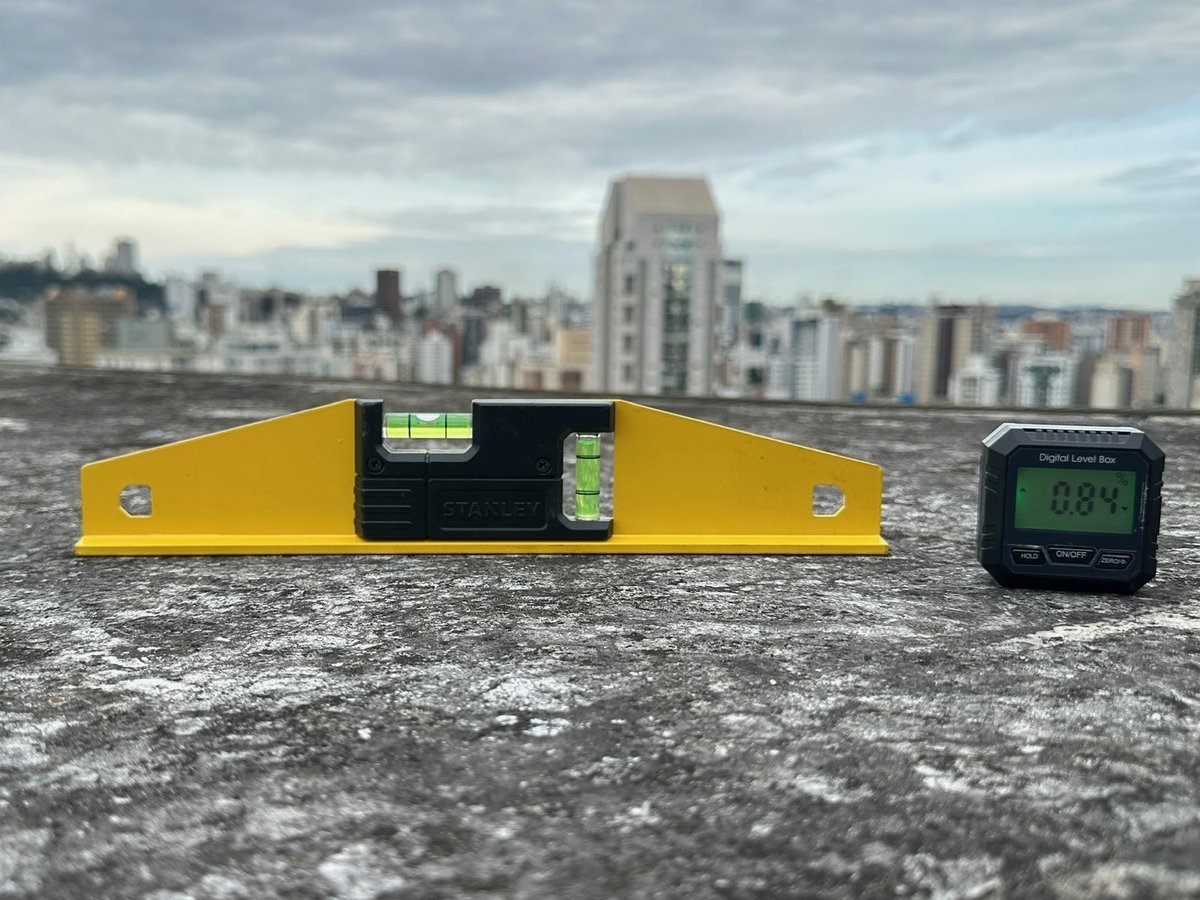 Nível de bolha e nível digital sobre a laje de cobertura de um edifício em Belo Horizonte