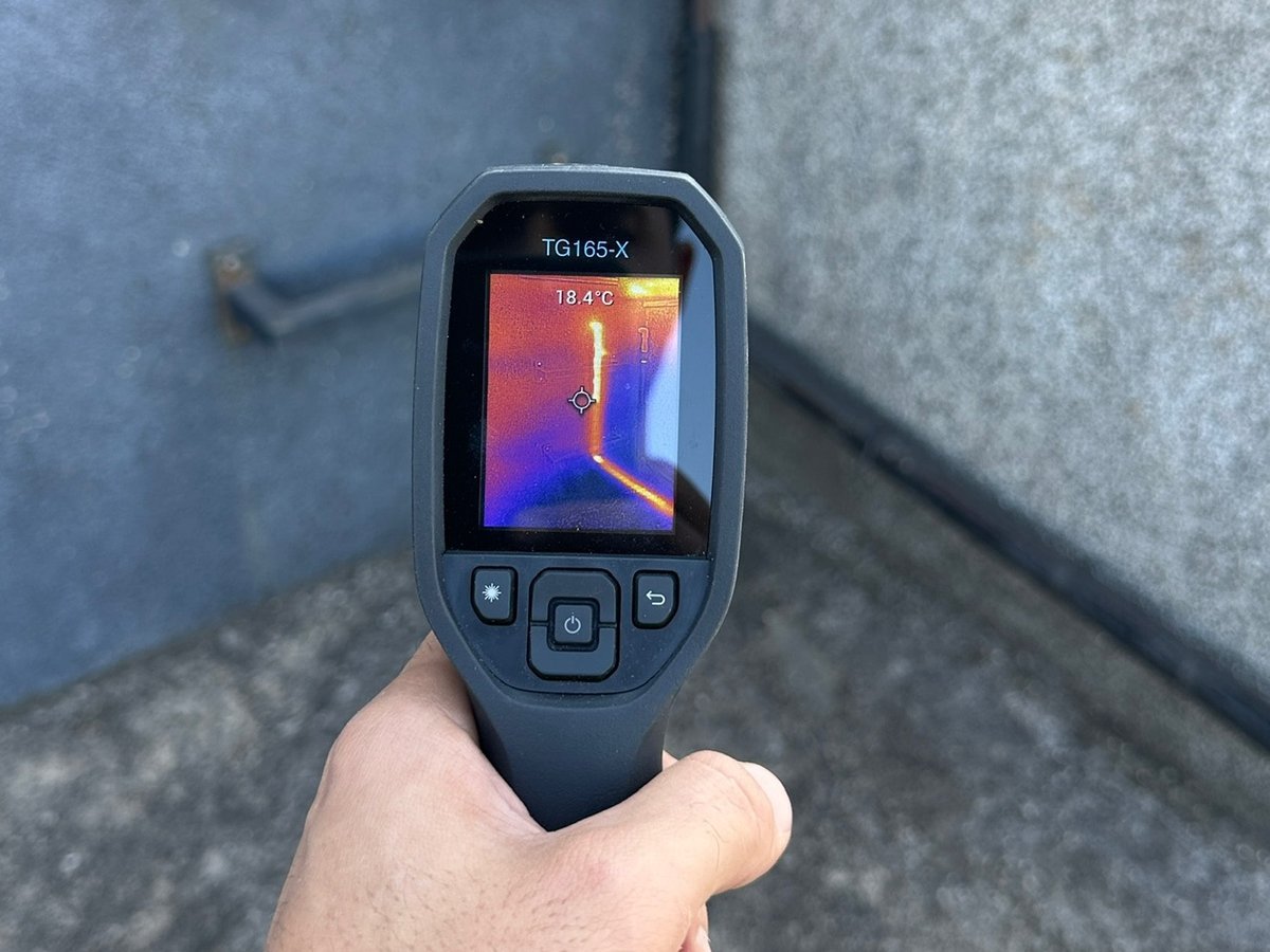 Câmera termográfica apontada para a parede durante investigação de infiltração