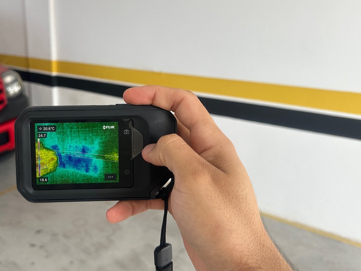 Câmera termográfica mostrando mancha de umidade em parede de garagem