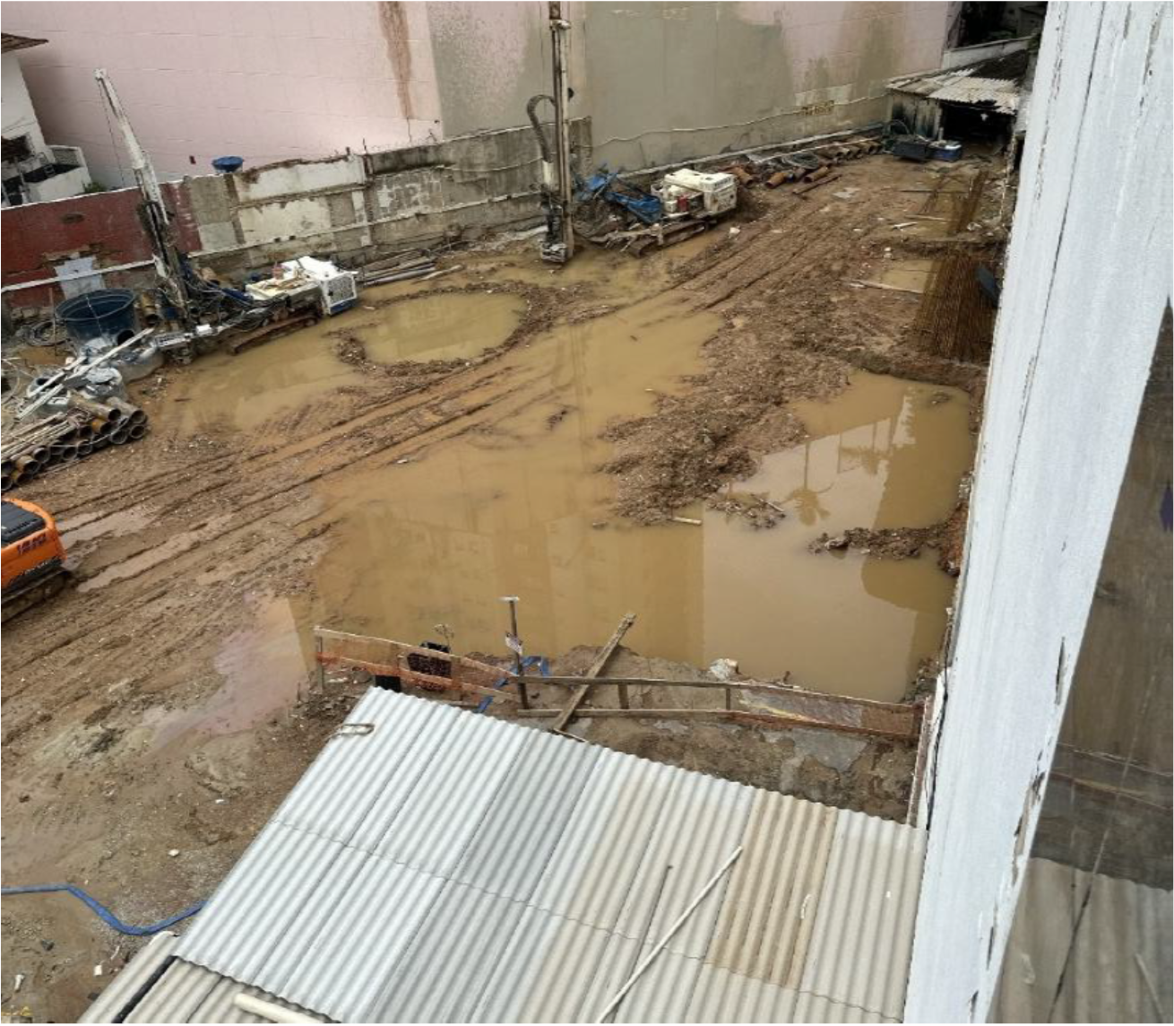 Canteiro de obra vizinho em estaca raiz, com água acumulada junto à parede de divisa